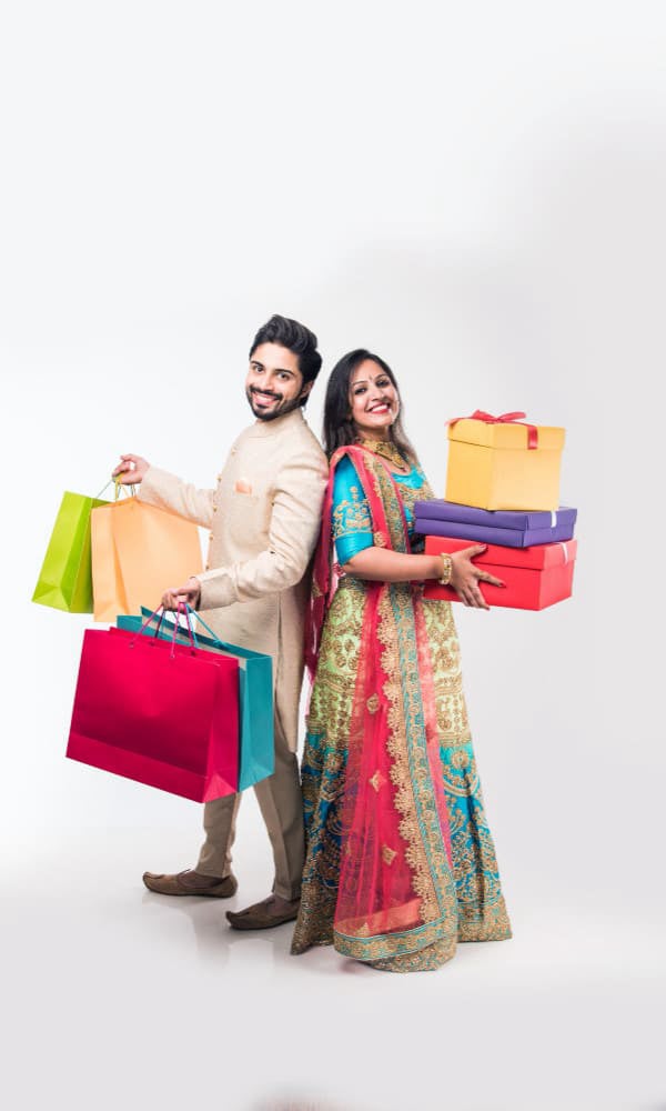 एक धनी भारतीय दम्पति कई शॉपिंग बैग लेकर जा रहा है